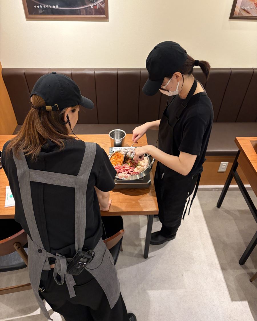 客席で鍋を仕上げるスタッフ